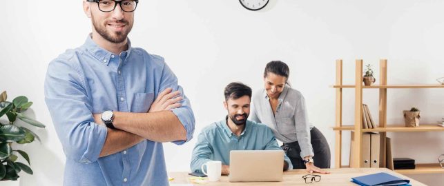 businessman-with-crossed-arms-standing-in-office-a-KYQGLWN-1-1